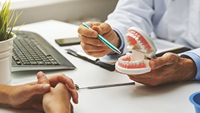 dentist showing client a model of teeth