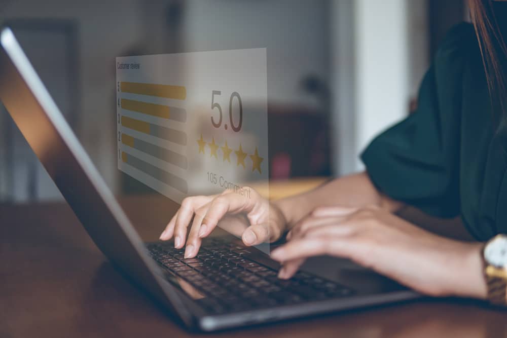 hands typing a five star google review on a laptop